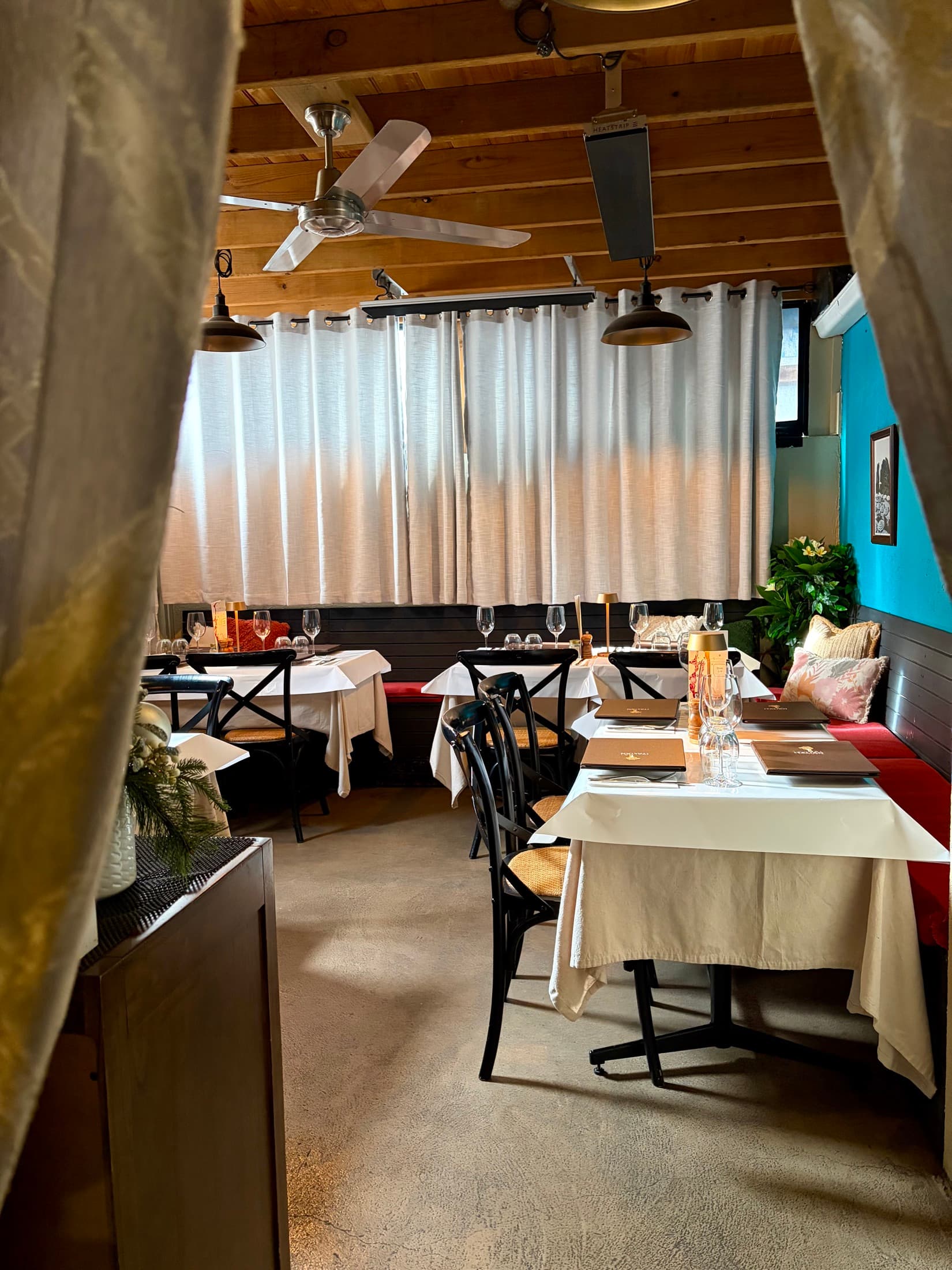 The Con Noi dining room — teal walls and linen-set tables